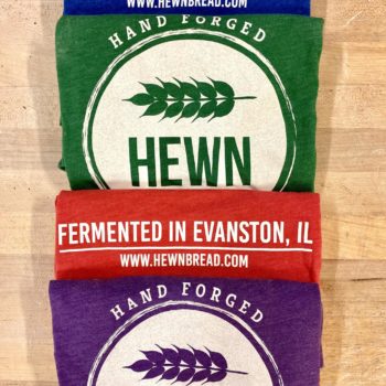 Colorful Hewn t-shirts with taglines "hand forged" and "fermented in Evanston, IL", www.hewbread.com